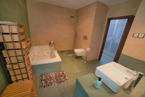 a bathroom with a tub and a sink and a toilet at CASA LAS 7 CEPAS moderna y acogedora en plena naturaleza in El Cristo del Espíritu Santo