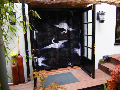 une porte en noir et blanc avec des oiseaux blancs dessus dans l'établissement Unique space in heart of Frome, à Frome