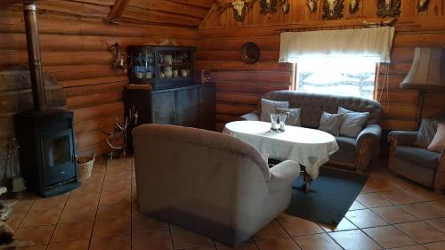 a living room with a table and chairs and a stove at Dzika Chata in Nowy Barkoczyn