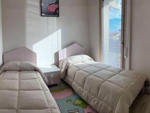 a bedroom with two beds and a window at Marco Polo Flat in Viareggio