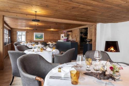 ein Restaurant mit Tischen und Stühlen und einem Kamin in der Unterkunft Appenzeller Huus Bären in Gonten