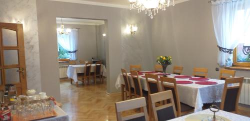 una sala da pranzo con tavolo, sedie e lampadario pendente di Zielona zagroda a Przyborów