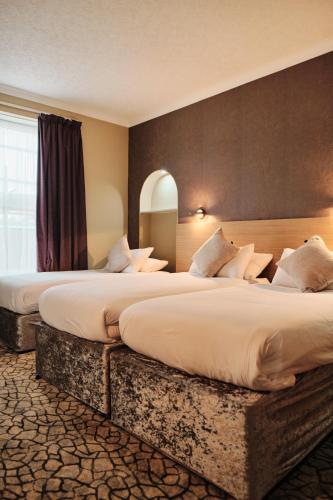 two beds in a hotel room with two bedsvisor at Hotel De Normandie in Saint Helier Jersey