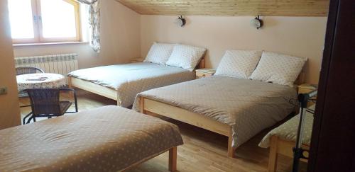 Habitación pequeña con 2 camas y mesa. en Zielona zagroda en Przyborów