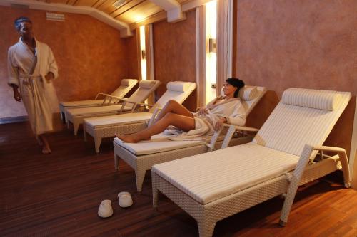 a woman sitting on chairs in a waiting room at MOTA hotel in Livigno