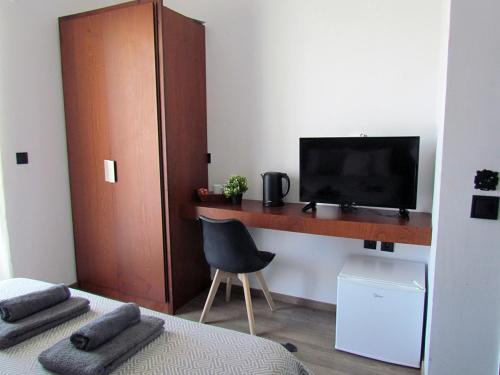 um quarto com uma secretária, uma televisão e uma cama em Li Mango em Tigaki