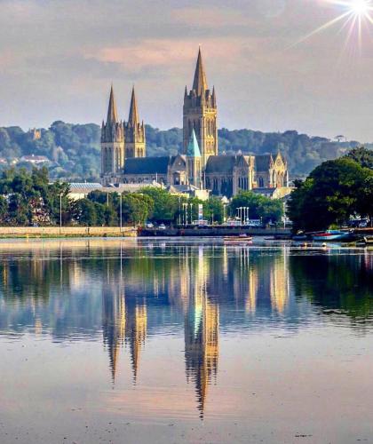 a large building with a reflection in a body of water at Mannings Hotel in Truro