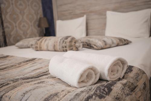 two rolled towels on a bed in a hotel room at Jermuk Moscow Health Resort in Jermuk