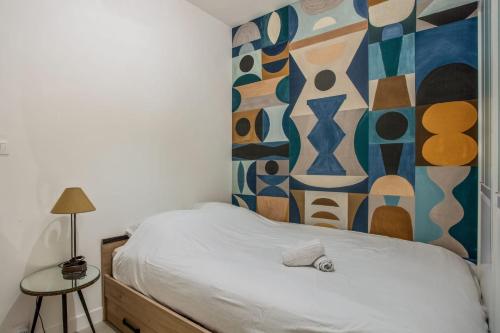 une chambre avec un lit avec un tableau sur le mur dans l'établissement Appartement Goncourt - Welkeys, à Paris