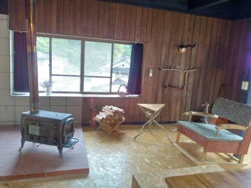 Kakomu - Vacation STAY 70352v في Kesennuma: غرفة معيشة مع موقد وأريكة