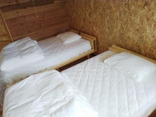 Kakomu - Vacation STAY 70352v في Kesennuma: سريرين في غرفة صغيرة ذات أغطية بيضاء