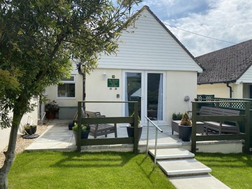 a house with a porch and stairs to the backdoor at Golden Acre Jurassic Coastal Lodges ,Eype in Bridport