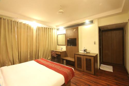 Habitación de hotel con cama y escritorio en HOTEL GARNET, en Durg