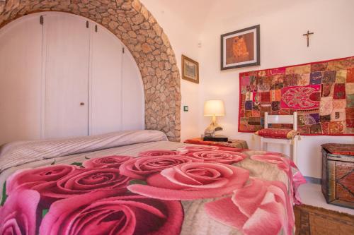 una camera da letto con un letto con coperte rosa di La Gariga a Lampedusa