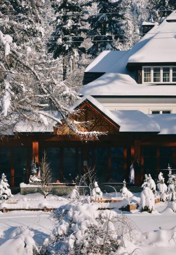 a house covered in snow with snow covered trees at Aries Hotel & SPA Wisła in Wisła