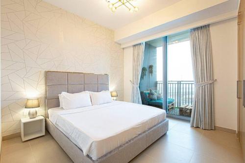 a bedroom with a large bed and a balcony at Stylish 1 Bedroom in 5242 by Ofex in Dubai