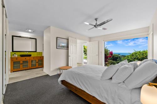um quarto com uma cama e uma grande janela em Spacious home with ocean views em Dromana