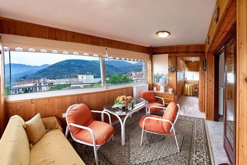 a living room with a couch and chairs and a table at Διαμέρισμα τρίτου ορόφου στην Δαύλεια με θέα in Dhávlia