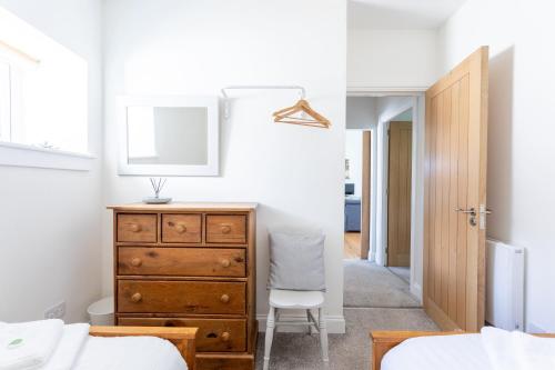 a bedroom with a dresser and a mirror at South Barlogan Farm in Bridge of Weir