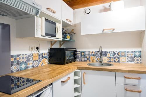une cuisine avec des armoires blanches et un évier dans l'établissement Appartement duplex 