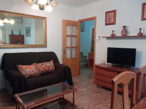 a living room with a couch and a tv at Casa Pinos in Siles