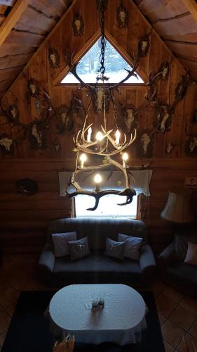 a chandelier in a room with a couch and a table at Dzika Chata in Nowy Barkoczyn