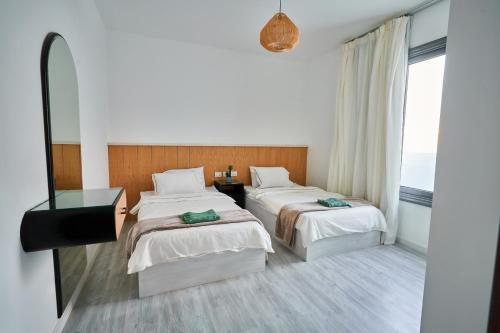 ein Hotelzimmer mit 2 Betten und einem Spiegel in der Unterkunft 3bds with private heated pool in Sholan 2 ElGouna in Hurghada