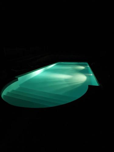 a green light in a dark room at DOMAINE DES 3 CYPRÈS Chambre PIVOINE Chez Nath & Pat in Fumel