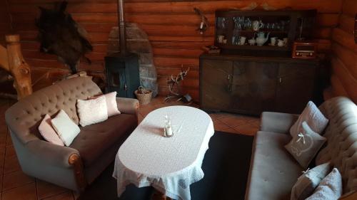 a living room with two couches and a table at Dzika Chata in Nowy Barkoczyn