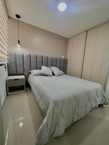 a bedroom with a large bed with a gray headboard at Apartamento amoblado cerca al aeropuerto in Pereira