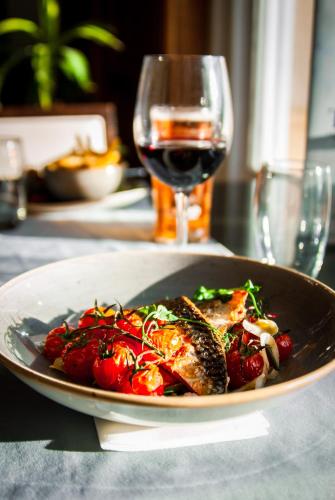 a plate of food on a table with a glass of wine at Trenython Manor Resort in Fowey