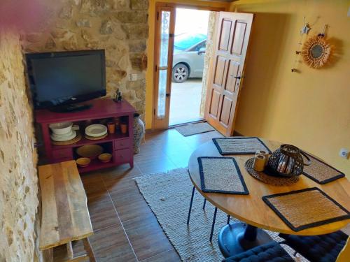 a living room with a table and a tv at Casa Rural Bella Culla in Culla