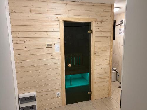 ein Badezimmer mit einer Holzwand und einer Tür in der Unterkunft Domwigierski pl -Jeziorki -Gospodarstwo Rolne- Comfort-Ferienhaus-Polen - własna linia brzegowa i sauna in Wysoki Most