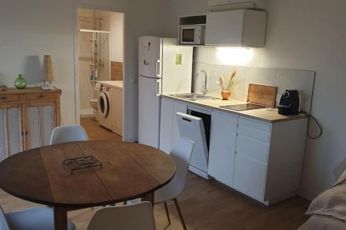 uma cozinha com uma mesa e uma cozinha com uma mesa e cadeiras em Appartement avec terrasse vue montagne em Grossa