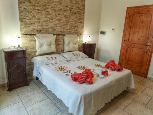una camera da letto con un letto con fiocchi rossi sopra di Xenios Torre Suda a Torre Suda