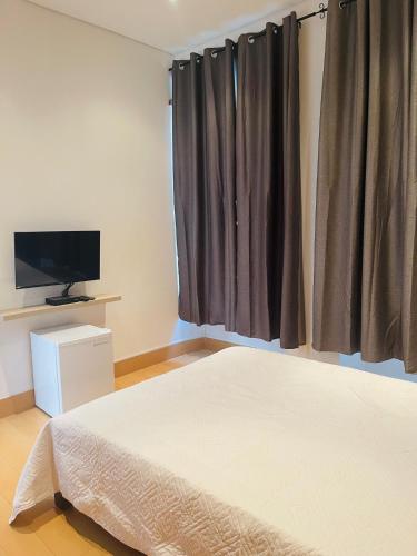 a bedroom with a bed and a flat screen tv at KAZARÃO DI MAVETE- Guesthouse in Praia