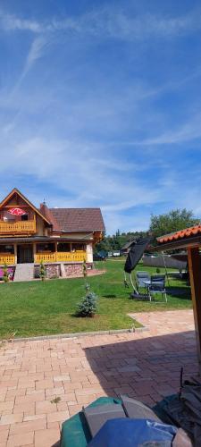 a building with a bench and an umbrella in front of it at GyenesCamping Wohnwagen Knaus 1 Rechts in Gyenesdiás