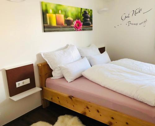 1 dormitorio con 1 cama con sábanas y almohadas blancas en Ferienwohnung Steiner, en Tulfes