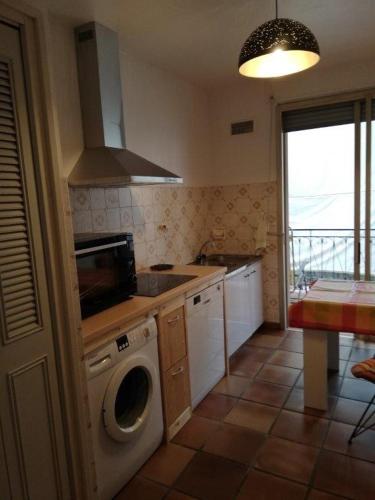 une cuisine avec une machine à laver dans une cuisine dans l'établissement Casa Rossa Solenzara, à Sari-Solenzara