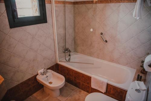 e bagno con vasca, servizi igienici e lavandino. di Hotel Rural La Figar ad Argüero