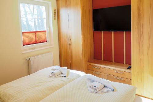 a bedroom with a bed and a flat screen tv at Villa Arielle, FW 5 in Zingst