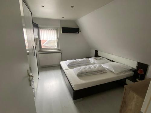 um pequeno quarto com uma cama e uma janela em Wohnen Nähe Nordpark em Mönchengladbach