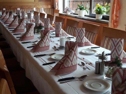 a long table with plates and napkins on it at Verwöhn-Pension Wiesengrund in Bischofsgrün