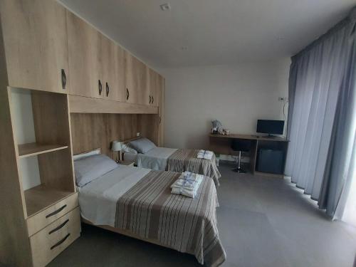 Habitación de hotel con 2 camas y escritorio en Civico 72, en Martano