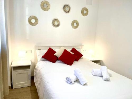 - un lit blanc avec des oreillers rouges et blancs dans l'établissement La Puerta de la Axerquía, à Cordoue