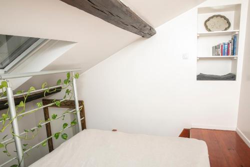 - une petite chambre mansardée avec un lit et une étagère dans l'établissement Cosy Studio !!!, à Paris