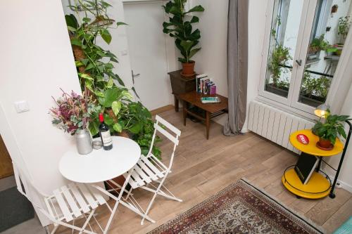 une pièce avec une table, des chaises et des plantes dans l'établissement Cosy Studio !!!, à Paris