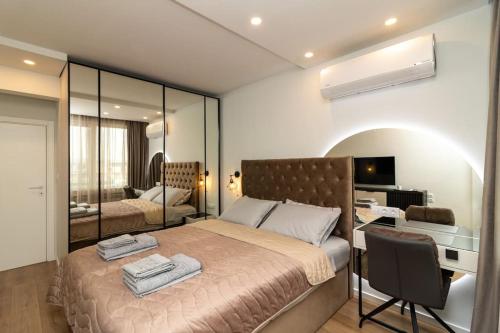 - une chambre avec un lit, un bureau et un miroir dans l'établissement Gran Capital Top Central Apartment, à Sofia