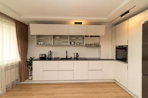- une cuisine blanche avec des armoires et des appareils blancs dans l'établissement Gran Capital Top Central Apartment, à Sofia