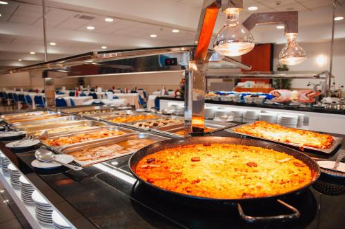 una línea de buffet con muchos tipos diferentes de comida en Hotel Playas de Torrevieja, en Torrevieja